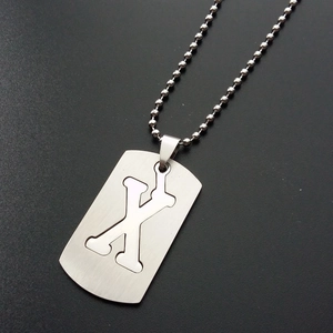 Close-up of stainless steel rectangle pendant with cutout letter X on bead chain