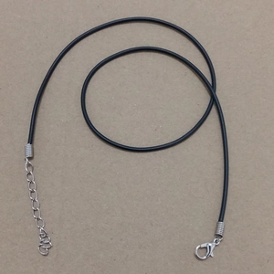 Detalle de collar de cordón negro con cierre de mosquetón plateado y cadena de extensión ajustable