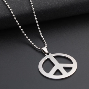 Macro shot of a silver steel peace sign pendant with a classic ball chain over black background