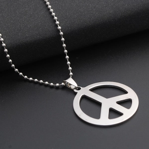 Close-up of stainless steel peace sign pendant with round bead chain on black surface