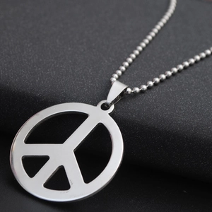 Macro shot of silver peace sign pendant with polished finish on a ball chain necklace