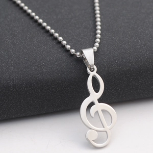 Macro detail of a silver treble clef musical note pendant with a sleek bead chain link