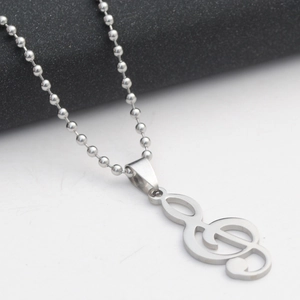 Macro view of a stainless steel treble clef pendant with a polished silver-tone ball chain