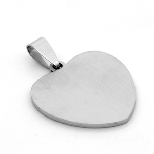 Macro shot of brushed heart-shaped stainless steel pendant with silver finish texture