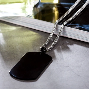 Dettaglio del ciondolo piastrina militare nera con catena in acciaio inossidabile argento