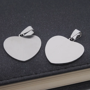 Close-up of heart-shaped stainless steel pendants with a brushed metal texture