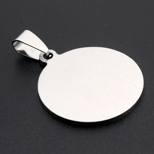 Detailed view of round stainless steel dog tag pendant with a brushed metallic texture finish