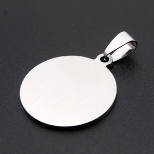 Close-up of a circular stainless steel pendant with a silver brushed metal finish texture