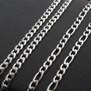 Polished silver stainless steel curb and Figaro chains on a black textured background