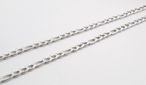 Detailed close-up of a silver Figaro style stainless steel chain necklace with polished finish
