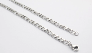 Detailed close-up of a silver stainless steel Figaro chain with a secure lobster clasp
