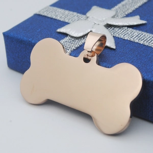 Close-up of rose gold bone-shaped pet ID tag on a blue gift box with ribbon