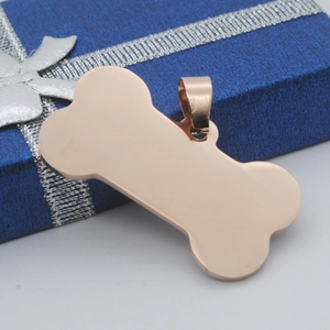 Polished rose gold bone-shaped pet ID tag with hanging loop on a blue gift box