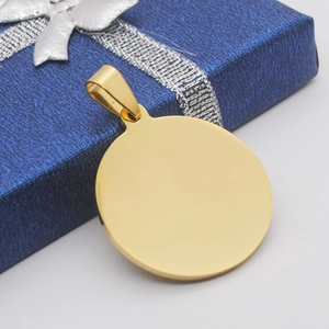 Colgante de placa redonda en oro pulido sobre una caja de regalo azul marino con cinta plata