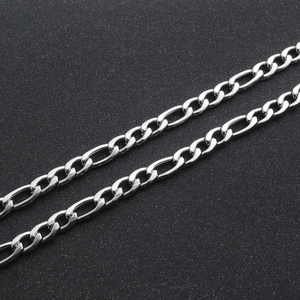 Polished silver Figaro chain necklace in stainless steel on a textured dark background