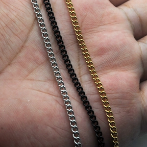 Drei Panzerketten in Silber, Gold und Schwarz präsentiert auf einer Handfläche