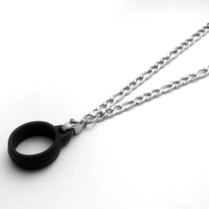 Detail of silver Figaro chain necklace with black silicone ring and lobster clasp connector
