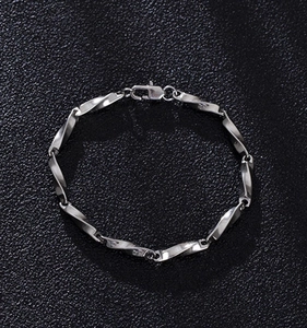Dettaglio macro del bracciale Mobius in acciaio argento con maglie intrecciate e chiusura