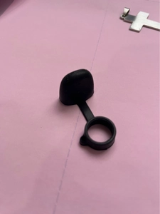 Macro detail of black silicone anti-dust cap with integrated tether ring for vaping devices