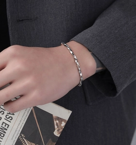 Dettaglio del bracciale Mobius in acciaio al titanio argento sul polso maschile