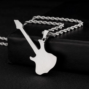 Detalle del collar con colgante de guitarra en metal cepillado sobre una caja negra