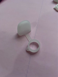 Detailed view of a translucent silicone dust cap with a flexible connecting strap