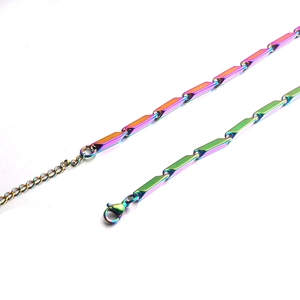 Dettaglio di una catena a maglie iridescenti in acciaio inossidabile con chiusura a moschettone