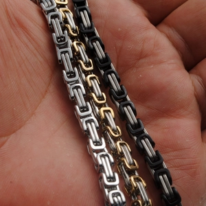 Three-tone Byzantine weave stainless steel necklaces displayed on a hand in various colors