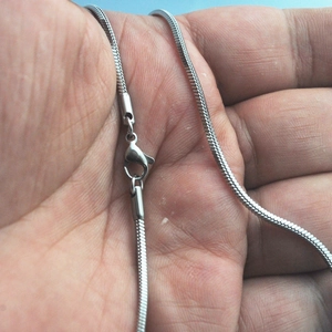 Close-up of a silver stainless steel square snake chain with a secure lobster clasp
