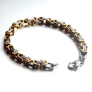 Close-up of gold and silver Byzantine chain bracelet with flat links and lobster clasp