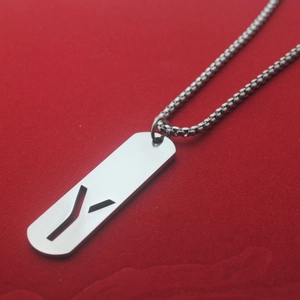 Detail of a rectangular stainless steel pendant with hollow design on a silver box chain