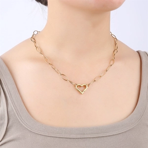 Collier en acier doré avec fermoir cœur et maillons ovales porté par un mannequin