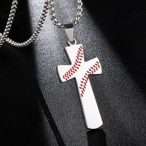 Croix en acier inoxydable poli avec coutures de baseball rouges sur fond de sable noir