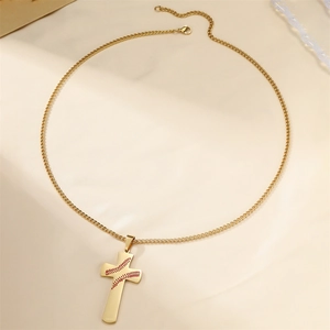 Collier pendentif croix de baseball en acier doré avec coutures rouges sur fond beige
