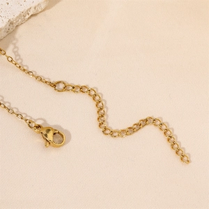 Détail d'un fermoir mousqueton doré et d'une chaîne d'extension pour collier tarot