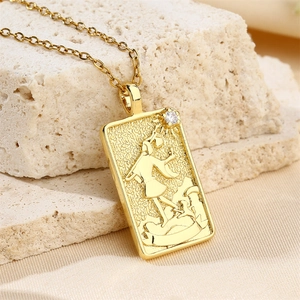 Detailed macro view of gold The Fool tarot card pendant necklace with a single zircon stone