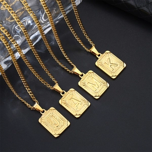 Detailopname van de vierkante 18k vergulde letterhangers met radiale textuur