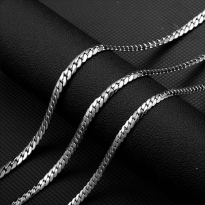 Macro detail of polished stainless steel cuban link chain on a dark textured background