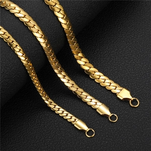 Close-up of three polished gold stainless steel flat link chains on black leather