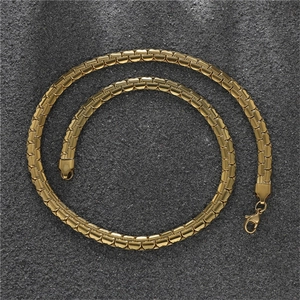 Detailed view of golden flat link chain with lobster clasp on a textured dark background