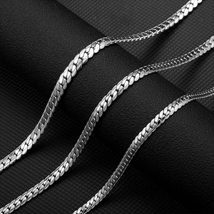 Macro detail of silver stainless steel flat curb link chains with textured finish