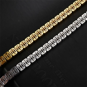 Detailaufnahme von hohlen quadratischen Gliederketten in Gold und Silber mit Sternmuster