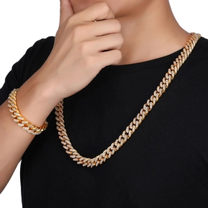 Close-up of iced-out gold Cuban link necklace and bracelet set with white rhinestones