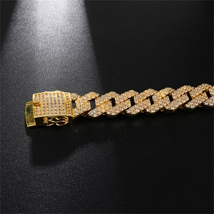 Detail van een goudkleurige Cubaanse schakelketting met een gezette zirkonia sluiting