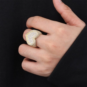 A detailed view of a luxury iced-out gold heart ring encrusted with clear zircons on a hand