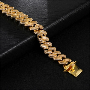 Detail van de gouden Cubaanse schakelketting met zirkonia en een vierkante sluiting