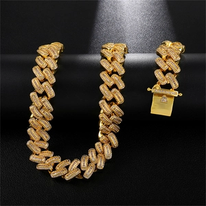 Detail van gouden cuban link ketting en armband set ingelegd met zirkonia ruitvorm steen