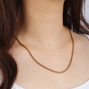 Detalle de un collar de cadena de caja en acero inoxidable chapado en oro de 18k