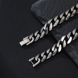 Close-up of brushed stainless steel Cuban link bracelet with a square clasp mechanism