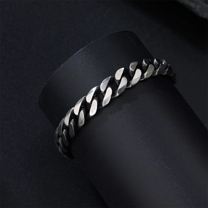 Macro detail of high-quality stainless steel Cuban chain bracelet on black display